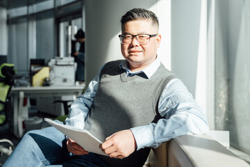 Portrait of Chinese man looking at document in office