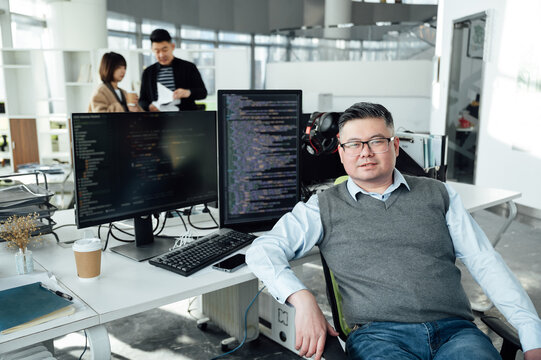Portrait of Chinese male engineer with computer in office