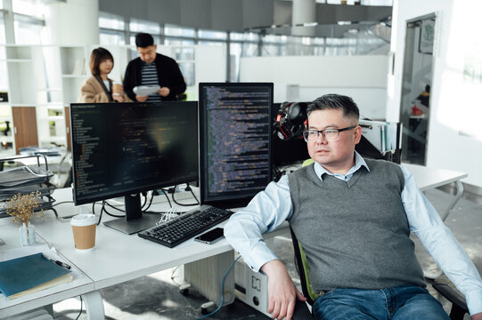Portrait of Chinese male engineer with computer in office