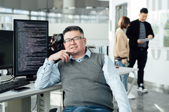 Portrait of Chinese male engineer with computer in office
