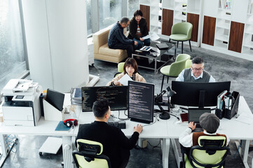 Casual business people working on computers in open plan office