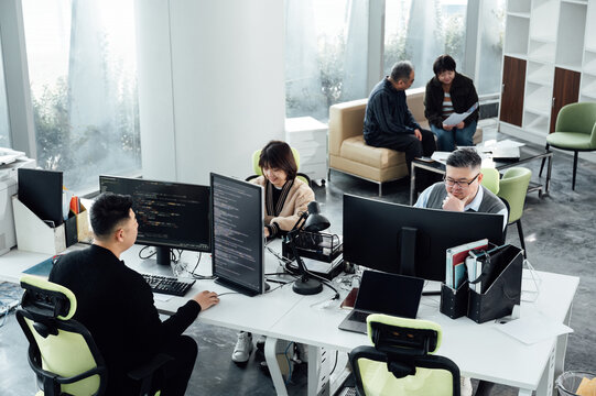 Casual business people working on computers in open plan office