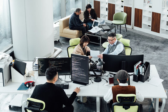 Casual business people working on computers in open plan office
