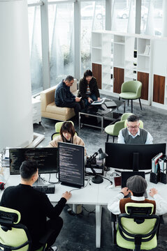 Casual business people working on computers in open plan office