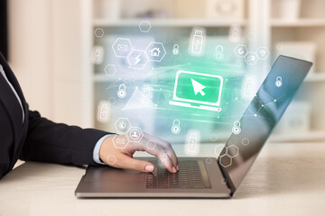 Hands working on laptop with digital icons