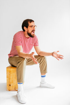 Man with Beard Sitting on Stool and Talking