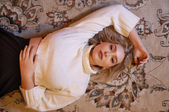 young woman lying on carpet