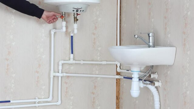 Plumber is connecting boiler to domestic plumbing system.