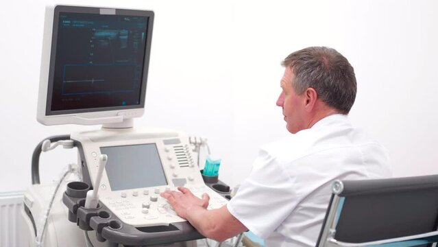 The doctor gives the woman an ultrasound of the thyroid gland.