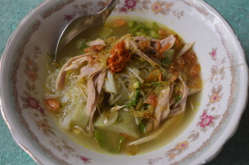 Soto ayam is a kind of chicken soup with a yellowish gravy, spices from turmeric, it contains sliced ​​​​meat, chicken, white noodles, sprouts, is a typical Indonesian food.