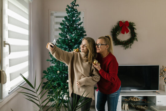 Mother and daughter taking pictures with smartphone