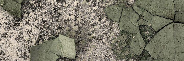 Peeling paint on the wall. Panorama of a concrete wall with old cracked flaking paint. Weathered rough painted surface with patterns of cracks and peeling. Wide panoramic grungy texture for background