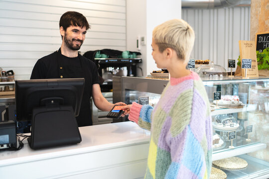 Woman paying with credit card in coffee shop