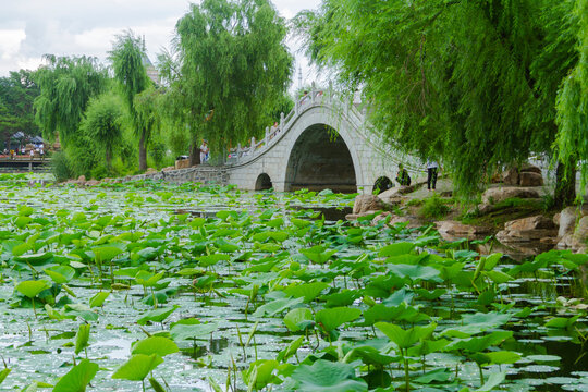 Changchun, Jilin - April 3 2021: Chinese stone arch bridge architecture on the lake in a park.