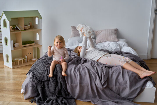 children are resting on the bed in their room