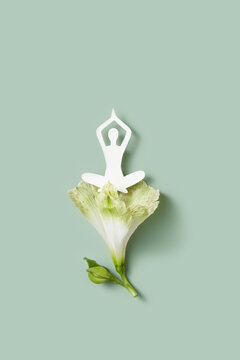 Paper female figure in lotus pose on green flower