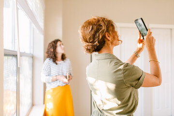 Interior designer taking picture of fan and ceiling