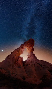 Desert arch with Milky Way extending into the sky beyond. 