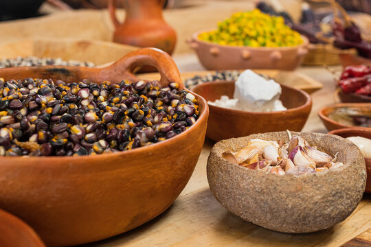 Kernels in a clay bowl with garlic and flowers on the background