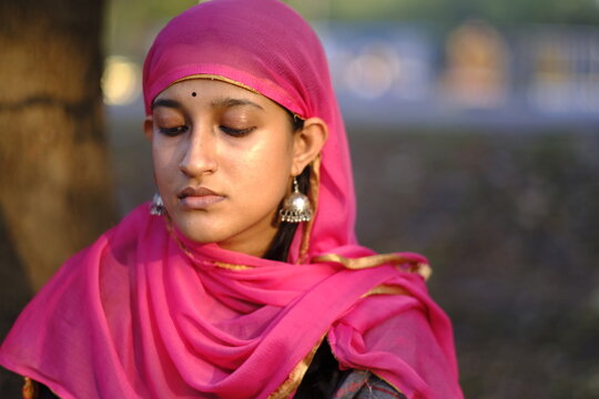 Young girl head shot covering head with colorful transparent cloths 