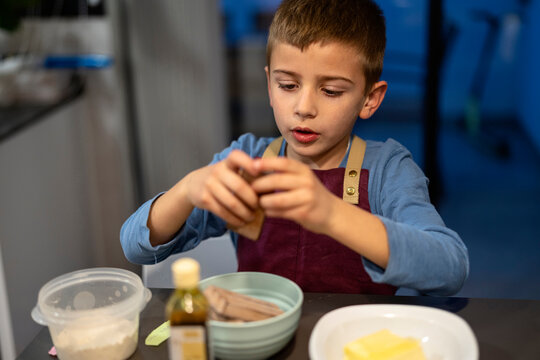 Boy preparing chocolate bar for making dessert