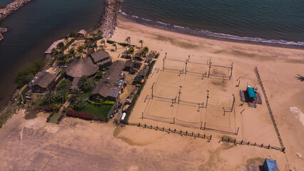 Photos from an aerial view of a drone, of a beach on a cloudy day from different angles and places, the tone of the photos is warm, in the photos you can see vegetation, trees, bushes, grass, sand, sk