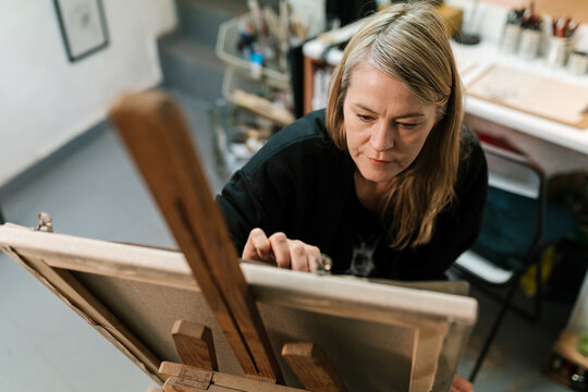 Creative artist drawing on easel in studio