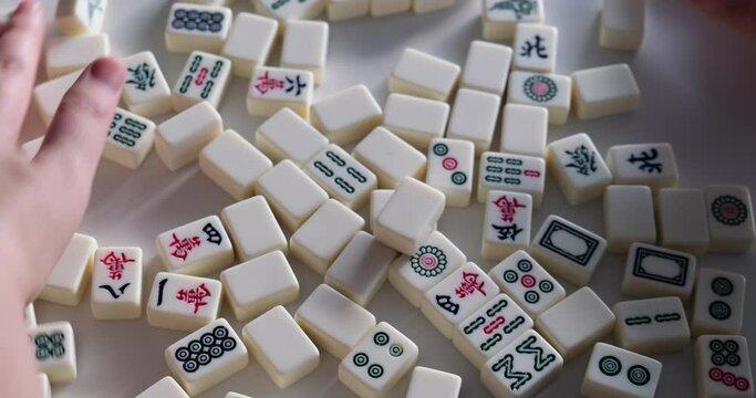 close up hands shuffling mahjong tiles. Slow motion. Traditional Chinese game