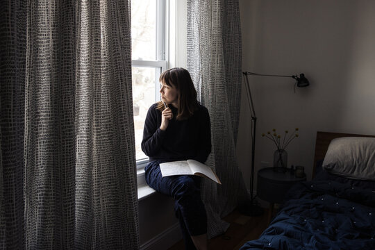 Woman writing a journal by the window