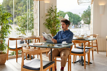 Male entrepreneur reading newspaper in morning