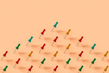 collection of colorful push pins on pink background