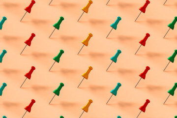 pattern of colorful push pins on pink background