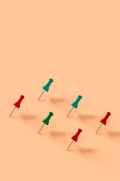 a row of colorful push pins on pink background