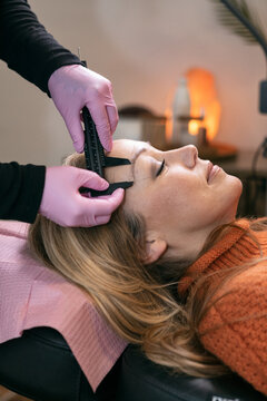 Aesthetician Measures Eyebrows Of Client