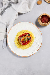 Eastern cuisine - stuffed paprika with mashed potatoes. Stuffed pepper with pure on ceramic plate in contemporary style. Modern concept eastern food menu. Aesthetic composition with main course.