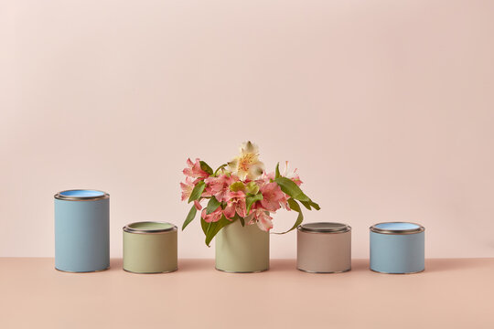 Various tin cans of pastel paints decorated with flowers
