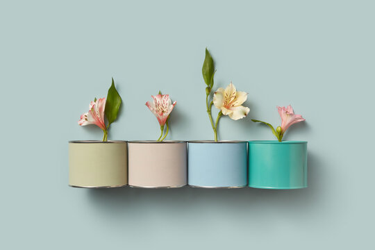 Tins of colored paints with spring flowers inside