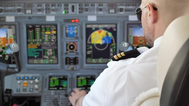 Over Shoulder Shot of Pilot in Airplane Cockpit Setting up Instruments