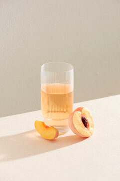 Several ripe peaches or nectarines and a glass of peach wine