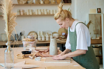 Young female potter working in her studio