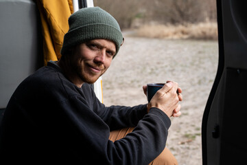 Portrait of happy man exploring nature with his dog by camper van