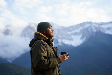 Portrait of happy man drinking coffee cup in the mountain