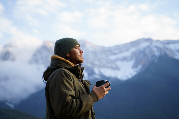 Portrait of happy man drinking coffee cup in the mountain