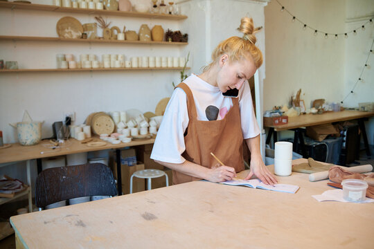 A female potter orders materials to the workshop