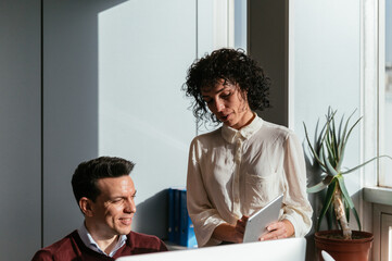 Happy colleague couple using computer in office desk