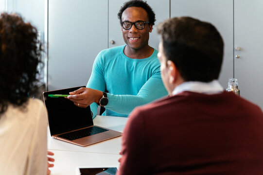 Cheerful black man in meeting at office with colleagues