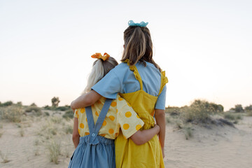 Sisters hugging each other outdoors