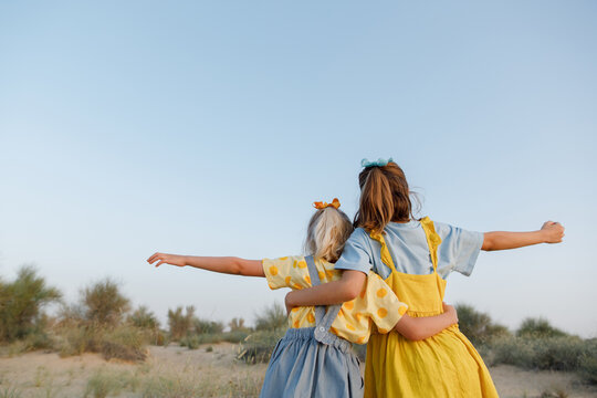 Sisters hugging each other outdoors