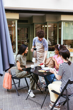 Group of diverse women in street cafe in summer