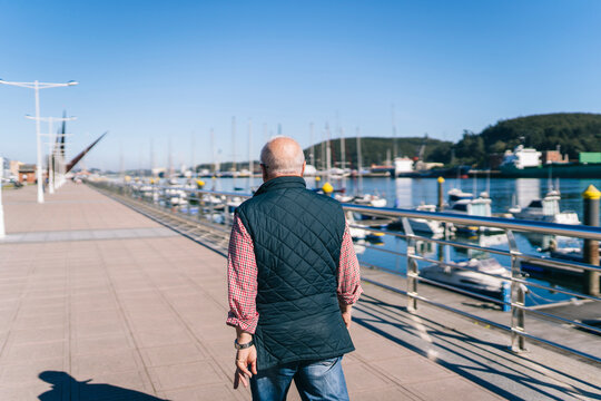 Anonymous pensioner walking along riverside